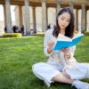芝生の上で本を読むアジア人女性2