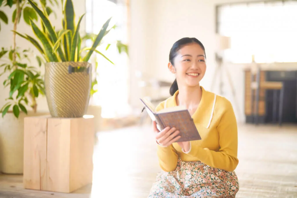 座って読書をしながらよそ見をする女性
