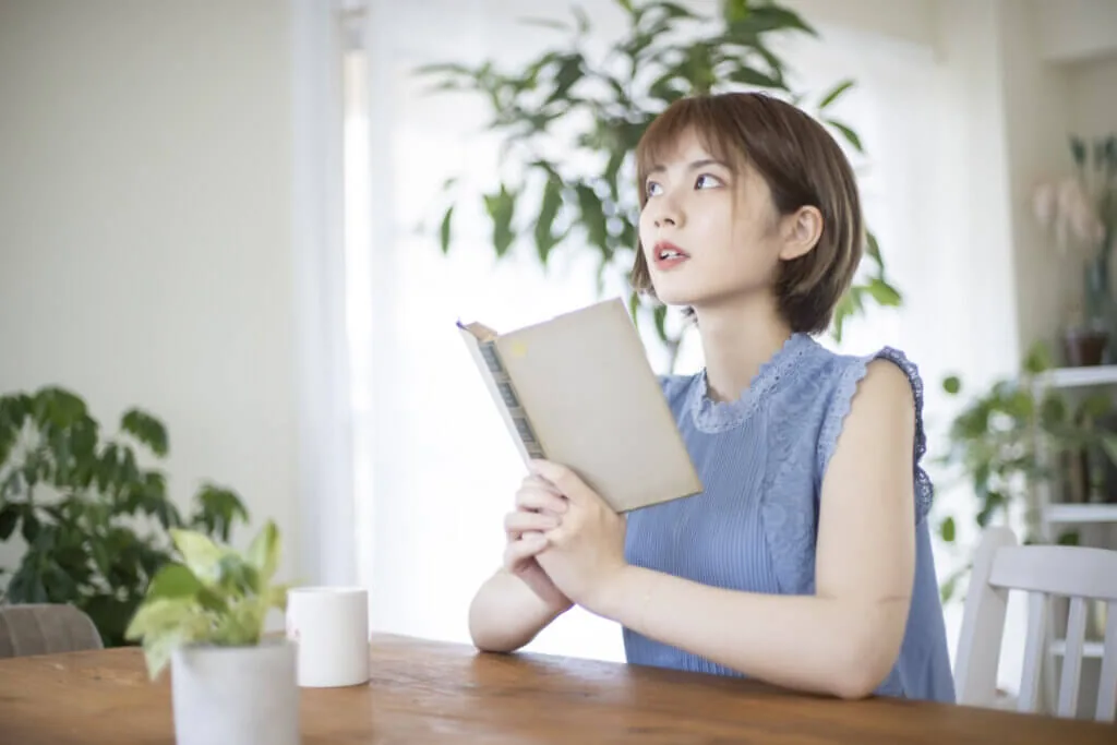 本を持ち考える女性